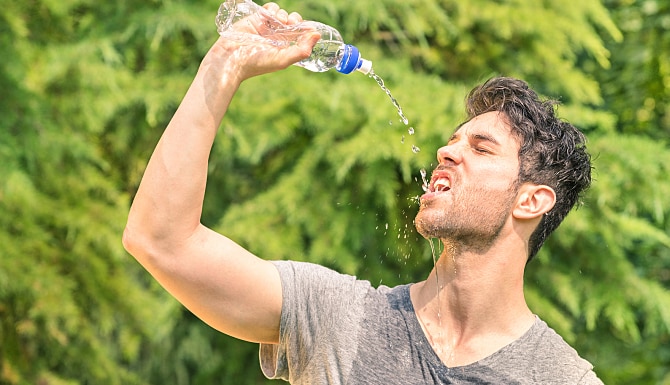 man drinking water from a bottle