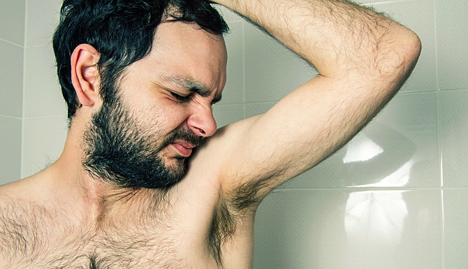 Man in the shower with a bad smell in his armpits