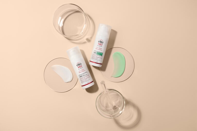 EltaMD sunscreen tubes placed alongside glass containers on a surface.