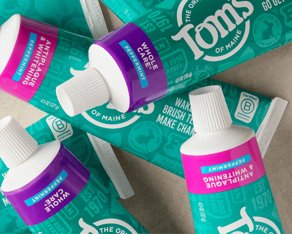 Tom's of Maine natural toothpaste tubes with fluoride-free and whitening varieties on a surface. 