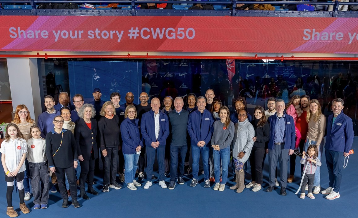 girls smiling on a  stage with colgate palmolive background in red