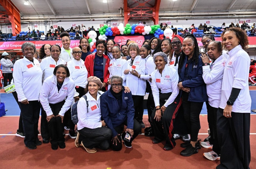 girls smiling on a  stage with colgate palmolive background in red