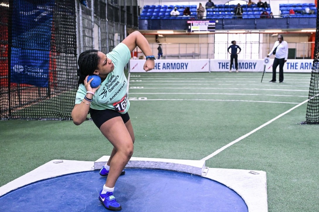 girls smiling on a  stage with colgate palmolive background in red