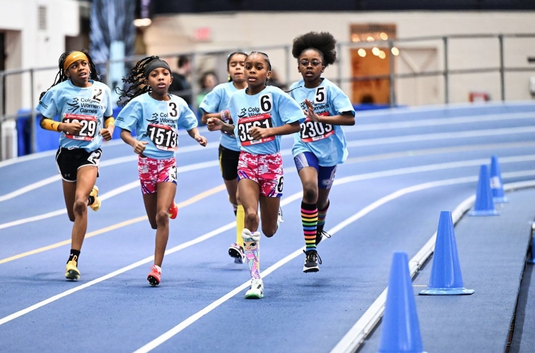 girls smiling on a  stage with colgate palmolive background in red