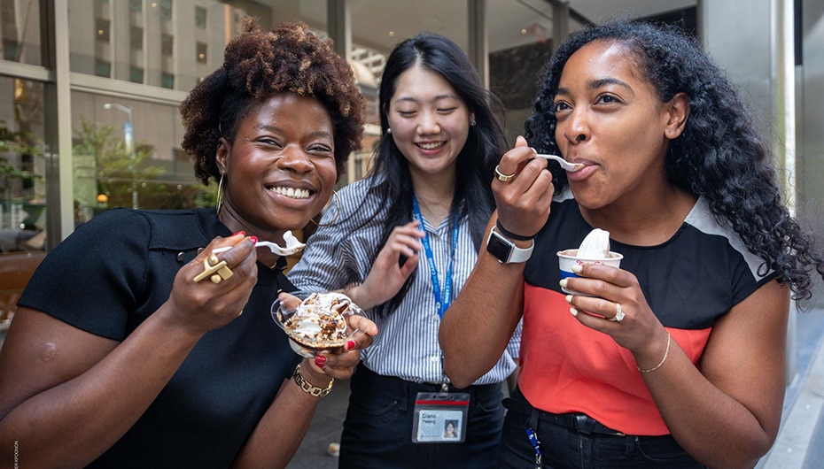 three woman smiling while eating ice cream